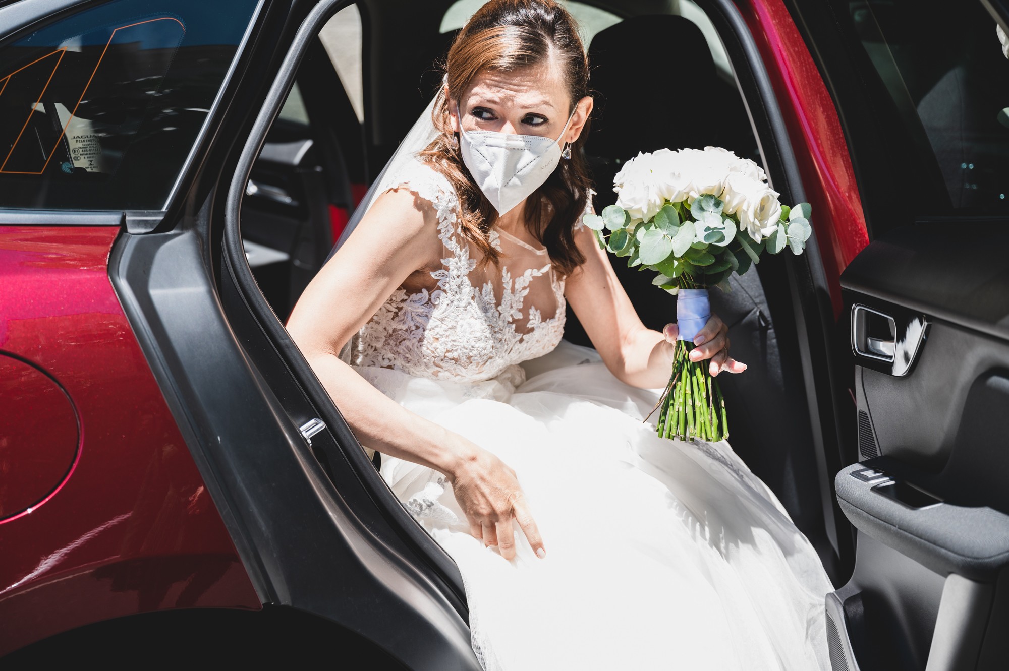 Novia bajándose del coche con mascarilla